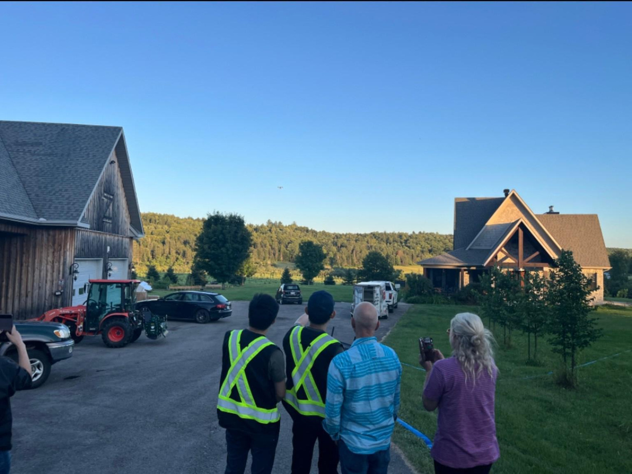 People observing equipment at a Quebec orchard field exchange.
