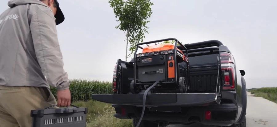 An operator carrying a battery towards a charging generator on a pickup.