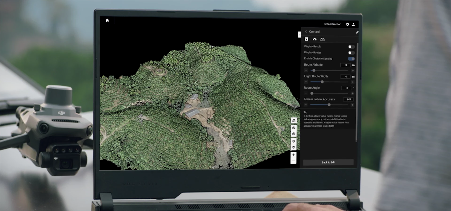 A laptop displaying an orchard reconstruction beside a Mavic drone in a DJI manufacturer demonstration.